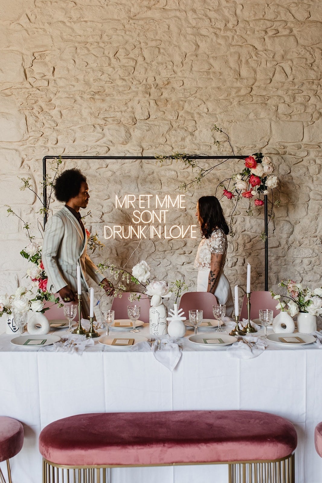 table des mariés blanche et rose avec un homme et une femme avancant l'un vers l'autre.