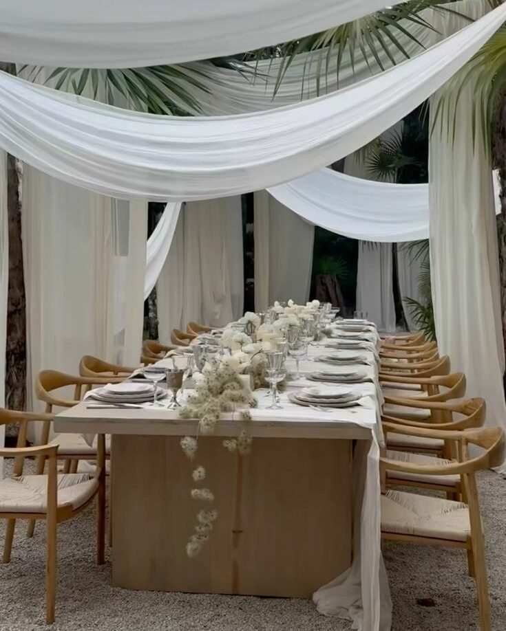 salle de réception mariage chic et bohème avec voilage blanc en extérieur