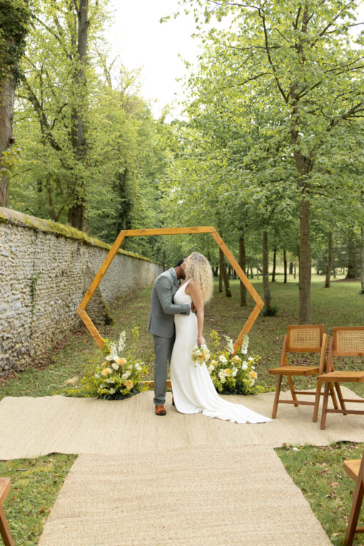 location décor arche de cérémonie octogonale en bois avec chaises et tapis en fibres naturelles